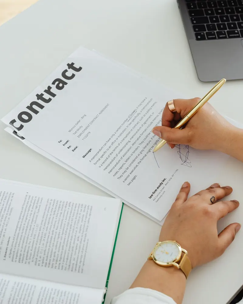 A person reading through a contract with a pen in hand