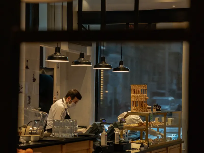 A baker working behind the counter of a small bakery